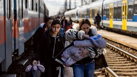 Getty Images Hundreds of people arrive at a train station in Hungary after fleeing Ukraine