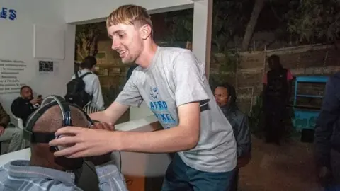 Ben Roberts Ben Roberts putting a headset on a man in Senegal