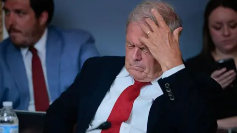 Getty Images Congressman Ralph Norman with his head in his hands looking exasperated at a hearing