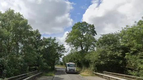 Google Road crossing the M1 in Leicestershire with lorry coming towards camera