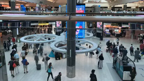 TW Photography A top shot inside a busy South Terminal with lots of distant unidentifiable people in distance.