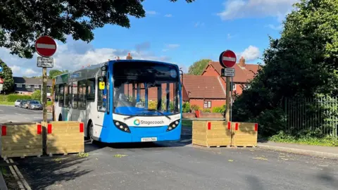 Bus driving through planters