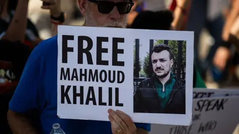 A protester holds a sign calling for Mahmoud Khalil's release 
