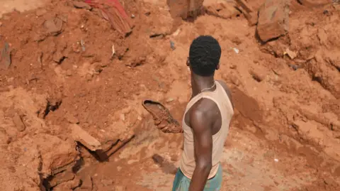A man standing among the debris left from the flood.