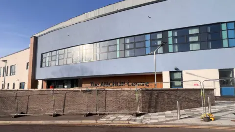 External view of the Anchor Centre in Aberdeen. It is a modern building and has temporary metal fencing around its perimeter.