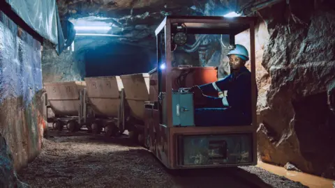 Trinity Metals A worker at a Trinity Metals mine in Rwanda is driving an underground train