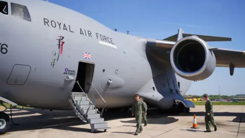 The aircrew of a Boeing C-17 Globemaster military transport aircraft, which is due to take part in the Royal Air Force flypast on May 5, during events marking the 80th Anniversary of VE Day, check the aircraft at RAF Brize Norton, Oxfordshire.