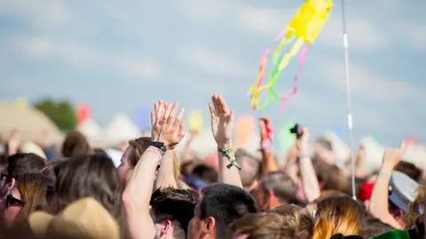 Getty Images A crowd of people with only the tops of their heads and shoulders in the air during a festival