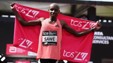 Getty Images Sabastian Sawe of Team Kenya celebrates crossing the line and winning with a new World Record time during the Men’s 2026 TCS London Marathon on April 26, 2026 in London, England.