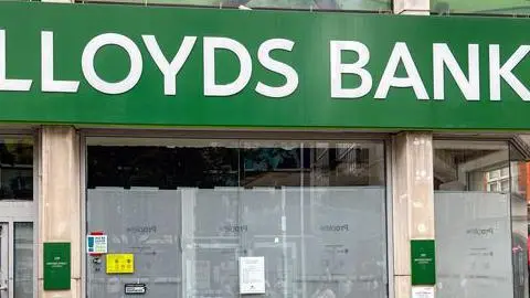 Mole Valley District Council A former Lloyds Bank branch now closed and boarded up; the typical green Lloyds signage is still visible, but the windows are obscured by a grey covering. 