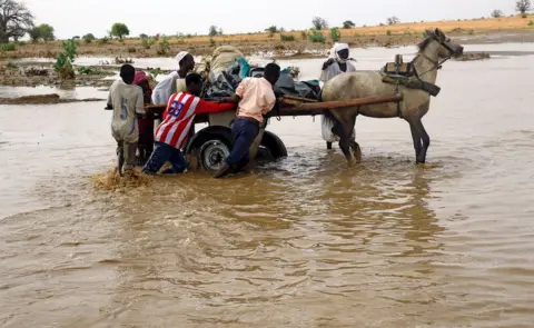 Reuters Displaced people carry their belongings to get away from flood during heavy rain at Nyala locality in South Darfur, Sudan 3 June 2017.