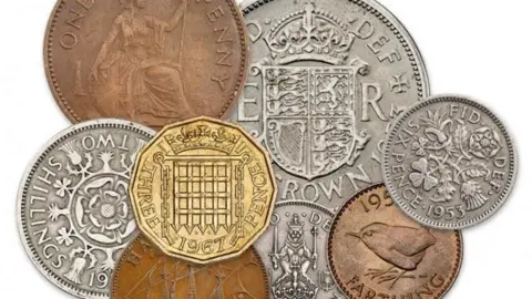 Copes Coins Images of pre-decimalised coinage superimposed on each other against a white background. They include a large silver crown, a smaller copper coloured penny showing Britannia, and a 12-sided thruppenny bit