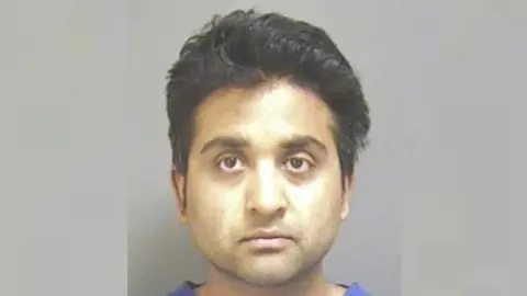 Devon and Cornwall Police Police mugshot of Salil Korambayil who is wearing scrubs