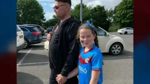 Family handout Dave with daughter Sydney wearing the shirt she was given for her eighth birthday