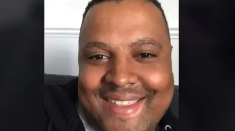 A man looks at the camera smiling.