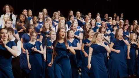 Barnsley Youth Choir A group of teenage girls wearing dark blue dresses singing in a choir