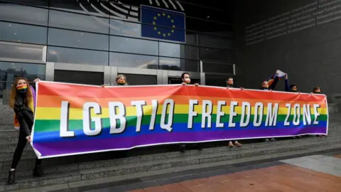 Getty Images People outside the European Parliament holding a banner that says "LGBTIQ Freedom Zone"