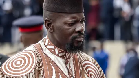 Guinea's President Mamady Doumbouya in a brown and white embroidered outfit in May 2026