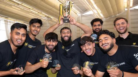 Cricket team celebrate with trophy