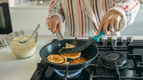 Person cooking on a gas hob