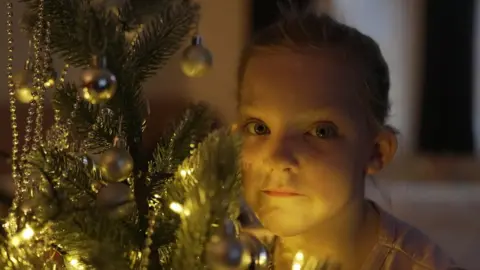 Bella next to a Christmas tree