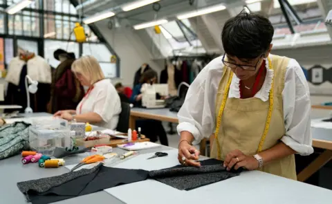 PA Media Men's costumier Susie England (right)