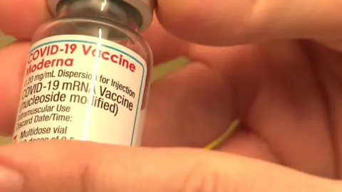 A close up of a Moderna vaccine vial.