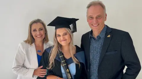 Family handout Gracie with her parents at her graduation