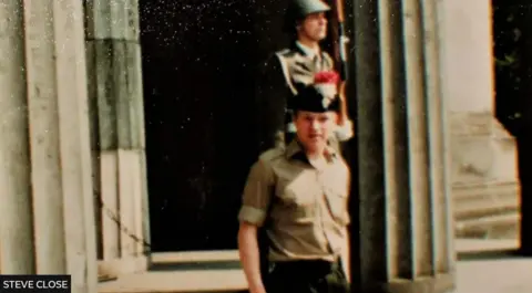 Steve Close Steve Close in Berlin in his uniform, with an armed soldier in the background 
