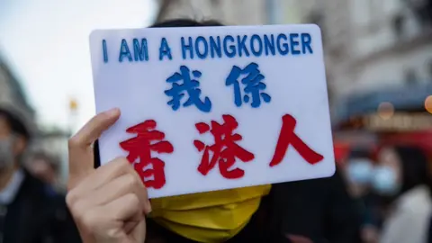 A woman holds a sign reading "I am a HongKonger"