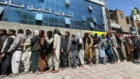 Getty Images Long queues outside banks in Kabul on 25 August 2021