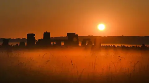 Stonehenge with the sun rising behind it