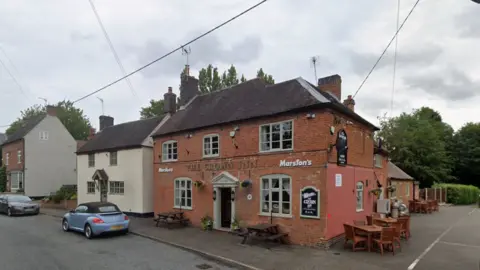 The Crown Inn with two cars at the front and a detached house next to it