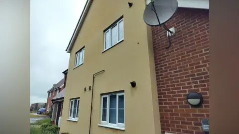 Supplied A photo of the outside of a block of flats. The middle part of the building features windows and is a sandy colour. Either side of that are brick walls.