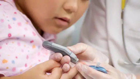 Getty Images Taking blood from a finger prick test