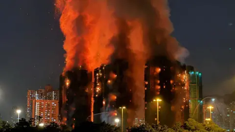 Yan ZHAO / AFP via Getty Images Night shot showing three tower blocks ablaze