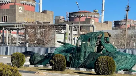 ENERGOATOM/Reuters A covered Russian tank outside the Zaporizhzhia nuclear power plant on 4 August