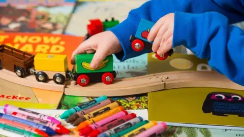 PA Child playing with wooden train set