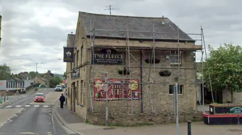 Google The exterior of a stone pub called The Fleece, which displays a banner for a drag night.