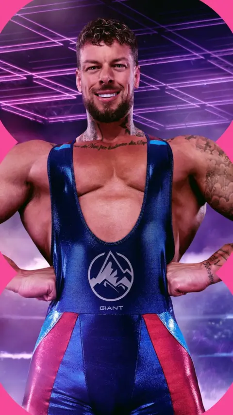 A man, Giant, dressed in his Gladiators leotard stands with his hands on his hips