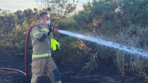 Gareth Perkins A firefighter with a hose