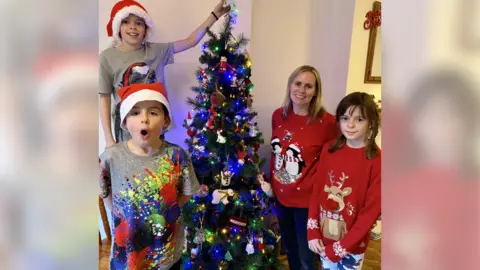 Cathryn Scott children and mother around Christmas tree