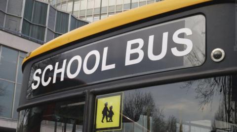 Yellow school bus front window with "school bus" destination sign