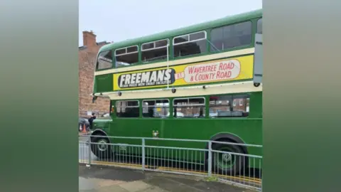 Danielle Twig A green and yellow bus with a retro advert which says Freemans at Wavertree Road & County Road
