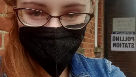@andreabarrett__ Andrea Barrett wearing a mask outside polling station