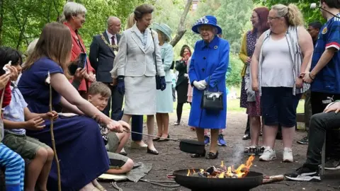 PA Media The Queen and Princess Anne stand in front of fire