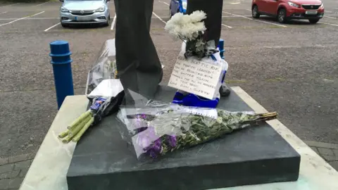 Floral tributes placed at the feet of the statue of Sir Bobby Robson