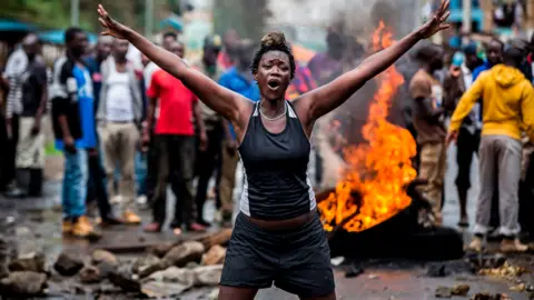 AFP An opposition supporter in front of a burning barricade in Nairobi as a group of demonstrators blocked the road and tried to prevent voters from accessing a polling station during presidential elections - 26 October 2017