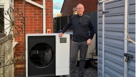 Anthony Hibbs Anthony Hibbs stands next to his heat pump at the back of his house