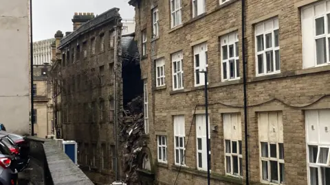 A large hole stretching down four storeys in a Yorkshire stone apartment block